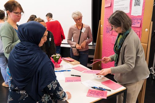 Feride Bozkurt (l. vorne) und weitere Teilnehmende diskutieren beim Word-Café.