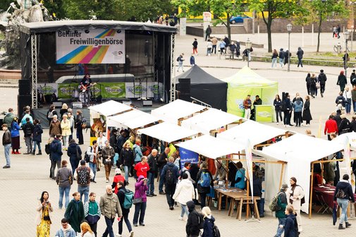 Auf dem Foto ist der Platz vor dem Roten Rathaus zu sehen mit einer großen Bühne und Ständen